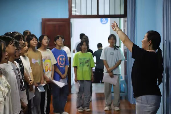 带队教师指导中学生练习齐唱。91热亚洲精品在线国产供稿图